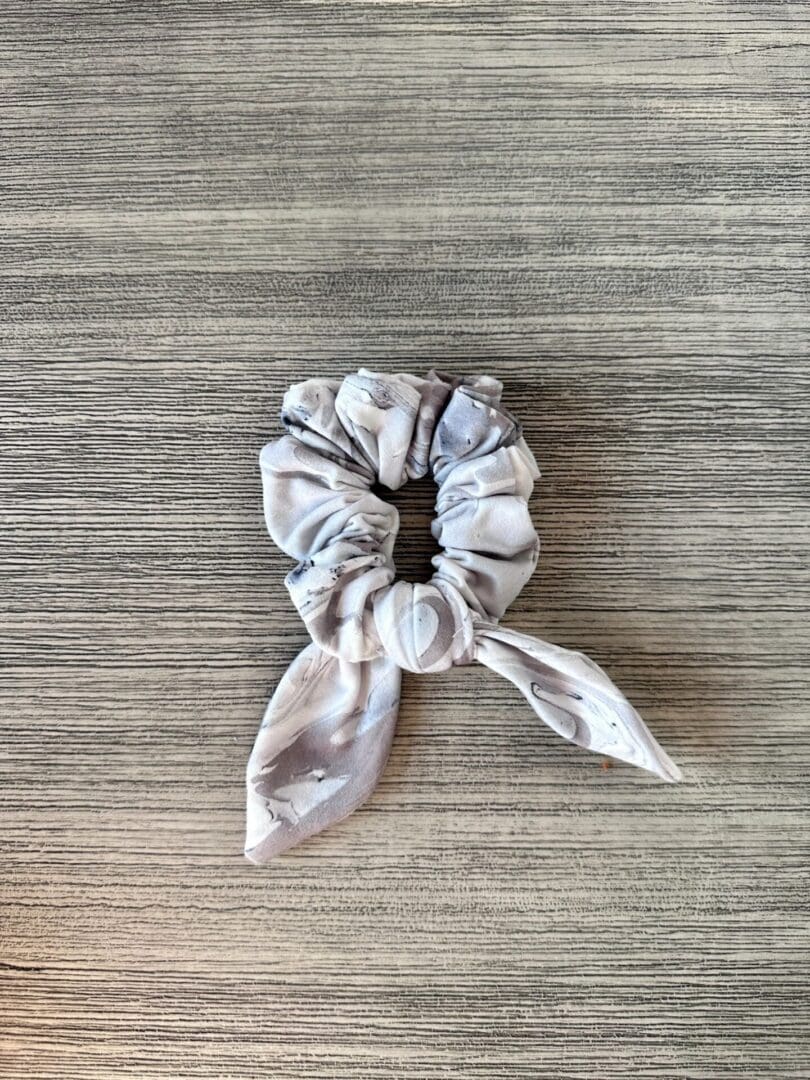 A Scrunchie - Gray & Taupe Abstract on a wooden table.